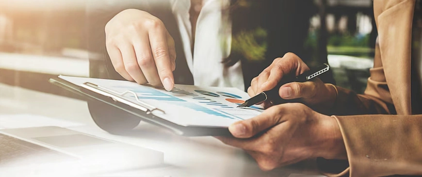 Two professionals reviewing financial charts and data reports, highlighting expert accounting services in Dubai