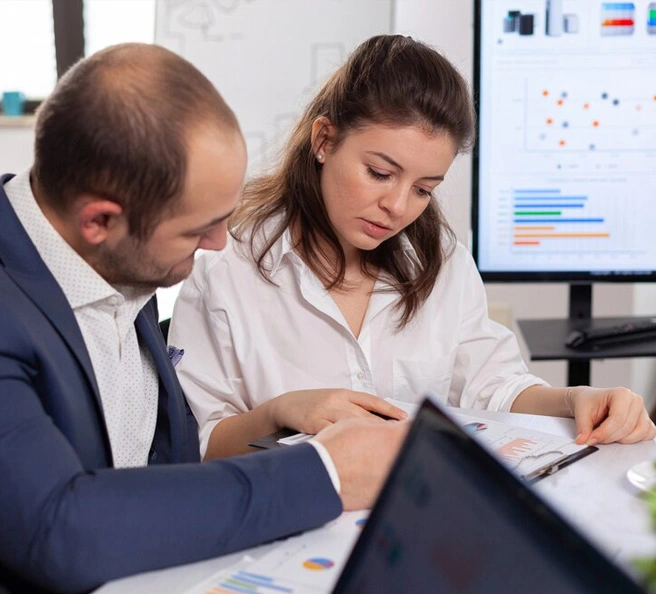Two financial consultants reviewing data charts in accounting and bookkeeping firm in Dubai
