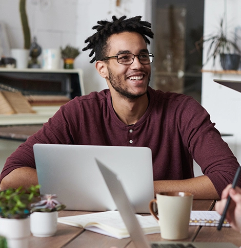 A smiling young entrepreneur using a laptop and discussing accounting and bookkeeping firm in Dubai